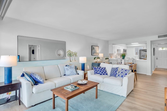 living room with sink and light hardwood / wood-style flooring