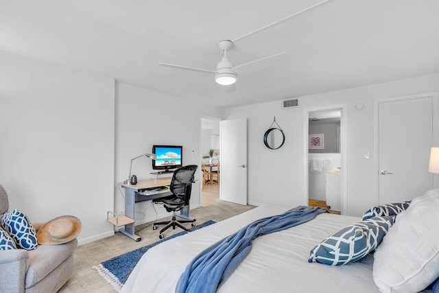 bedroom with ceiling fan, light colored carpet, and ensuite bathroom