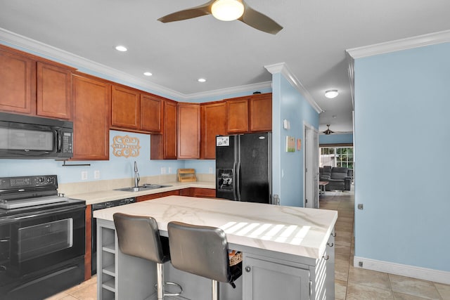 kitchen with sink, a breakfast bar, ceiling fan, ornamental molding, and black appliances