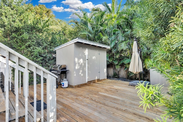 wooden deck featuring a storage shed and grilling area