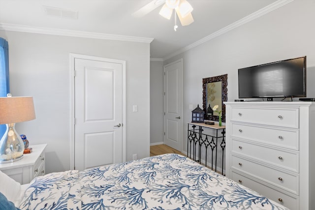 bedroom with crown molding, ceiling fan, and light hardwood / wood-style floors