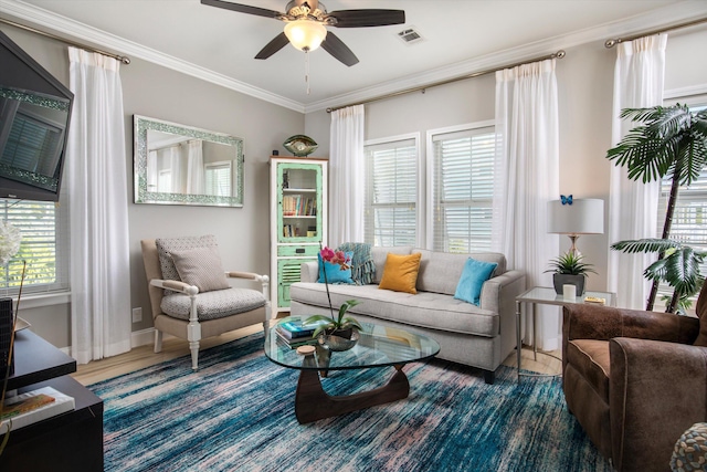 living area with ornamental molding and ceiling fan