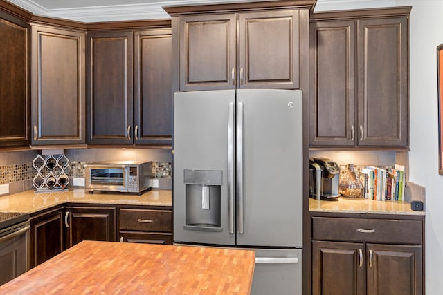 kitchen with appliances with stainless steel finishes, wooden counters, and dark brown cabinetry