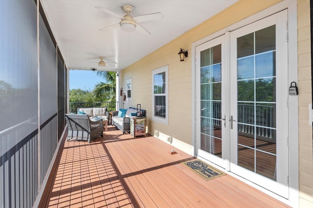 wooden deck with french doors, ceiling fan, and an outdoor hangout area