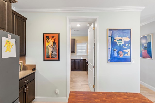 hallway featuring crown molding and light wood-type flooring