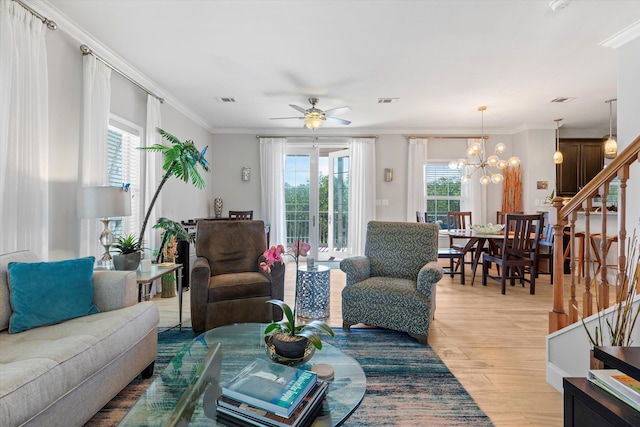 living room featuring crown molding, ceiling fan with notable chandelier, a wealth of natural light, and light hardwood / wood-style floors