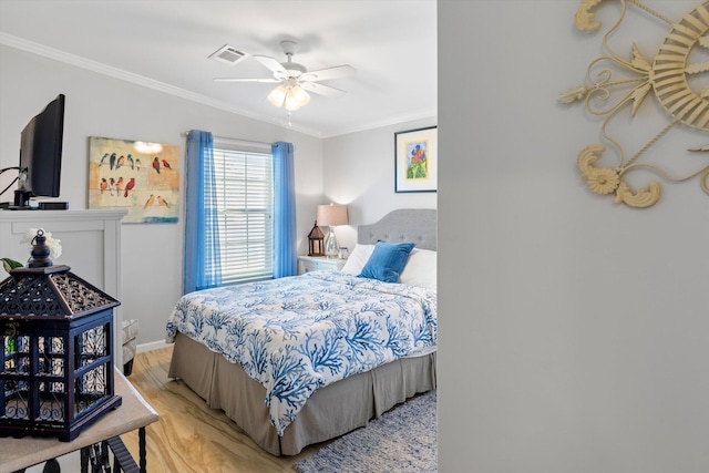 bedroom featuring ceiling fan, ornamental molding, and light hardwood / wood-style floors