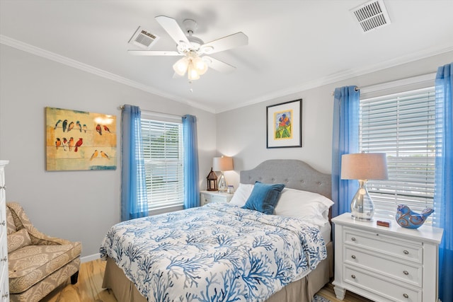 bedroom featuring crown molding, light hardwood / wood-style flooring, and ceiling fan