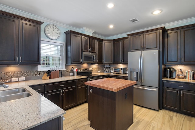 kitchen featuring a kitchen island, tasteful backsplash, sink, wooden counters, and stainless steel appliances