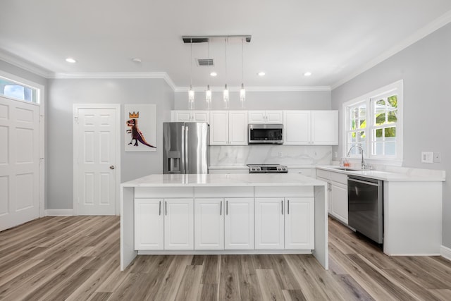 kitchen with pendant lighting, sink, a kitchen island, and appliances with stainless steel finishes