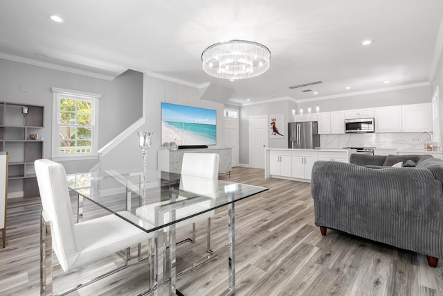 dining space featuring crown molding, light hardwood / wood-style floors, and a chandelier