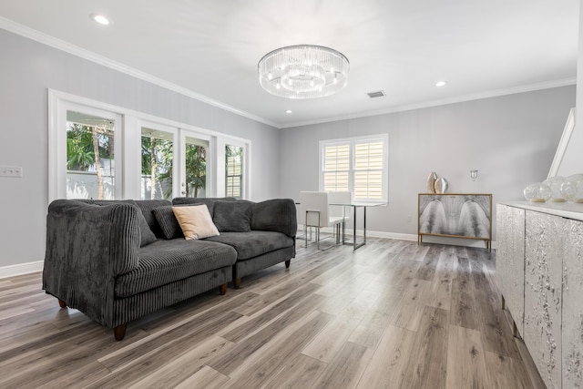 living room featuring wood-type flooring, a notable chandelier, and crown molding