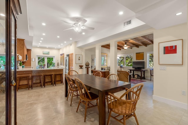 tiled dining area with beamed ceiling and ceiling fan