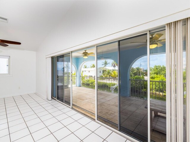 interior space with light tile patterned flooring, ceiling fan, and vaulted ceiling