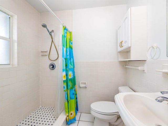 bathroom with toilet, sink, a shower with shower curtain, and tile walls