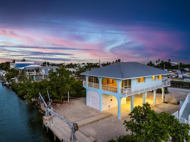 view of front of house with a dock and a water view