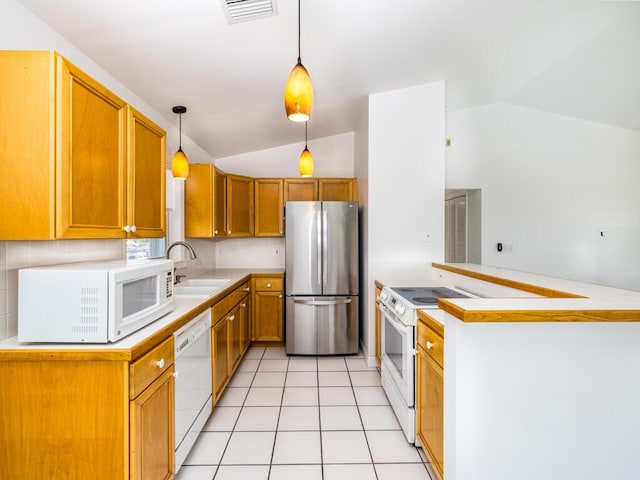 kitchen with sink, white appliances, vaulted ceiling, and decorative light fixtures