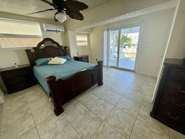 bedroom featuring light tile patterned flooring, a ceiling fan, baseboards, access to exterior, and a wall mounted air conditioner