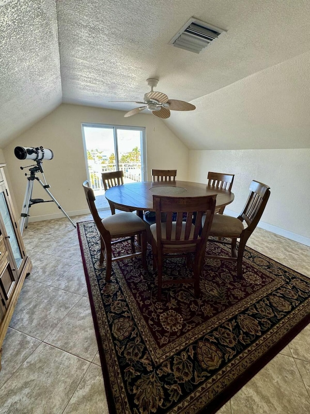 dining area featuring a textured ceiling, vaulted ceiling, visible vents, and baseboards