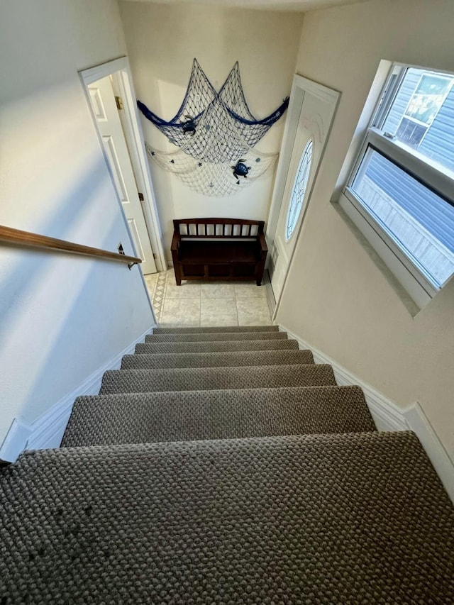stairs featuring tile patterned flooring and baseboards