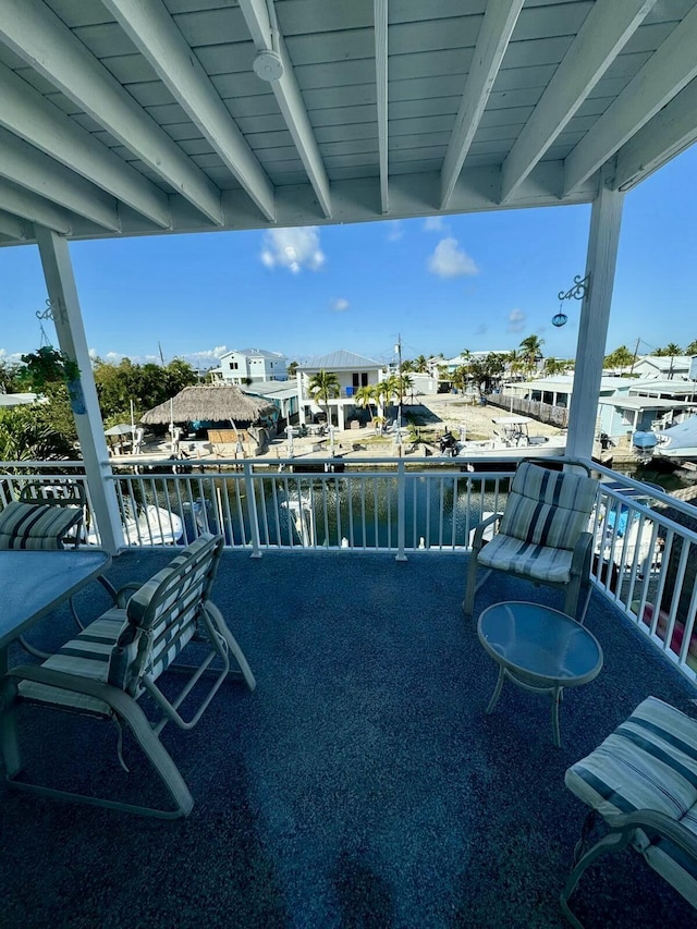view of patio featuring a water view and a balcony
