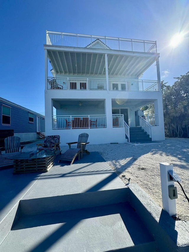 rear view of house featuring a patio and a balcony