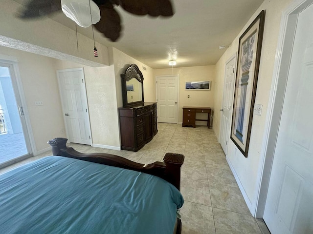 bedroom with light tile patterned floors, ceiling fan, and baseboards