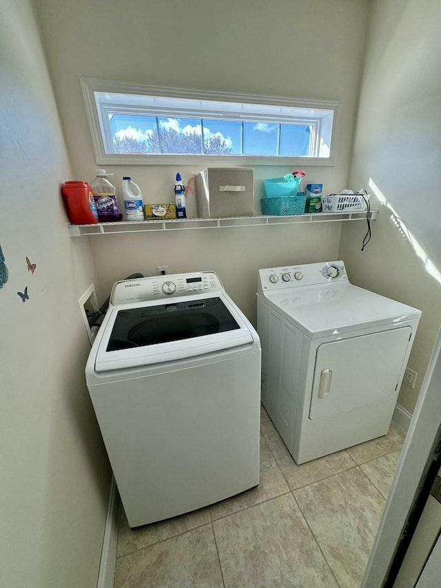 laundry room featuring light tile patterned floors, laundry area, and washer and clothes dryer