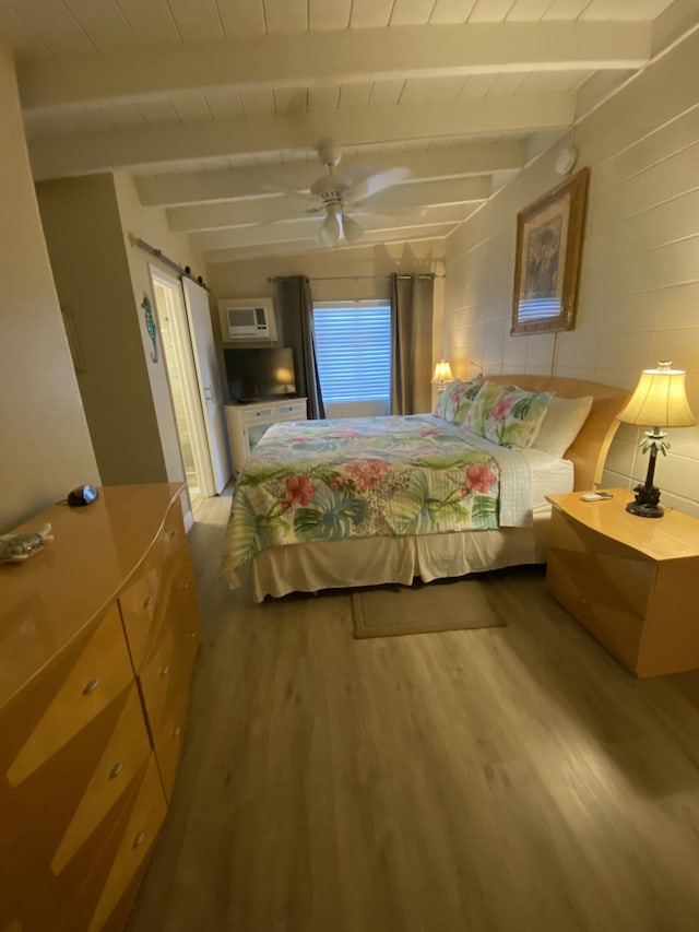 bedroom with wood ceiling, hardwood / wood-style flooring, a barn door, and beamed ceiling