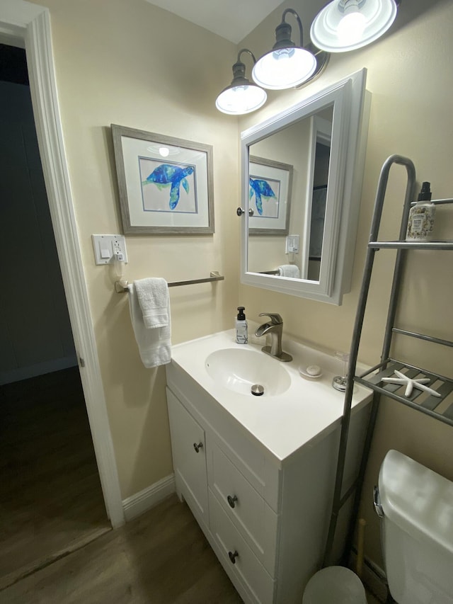 bathroom with vanity, hardwood / wood-style floors, and toilet