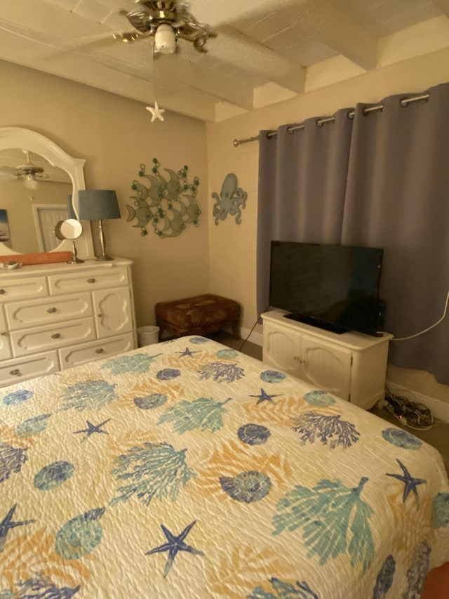 bedroom featuring ceiling fan and beamed ceiling