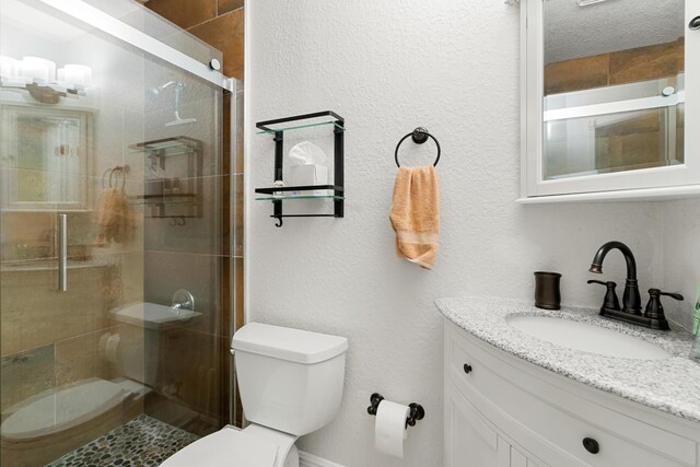 bathroom featuring vanity, an enclosed shower, a textured ceiling, and toilet