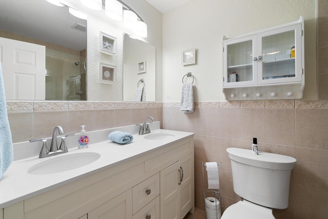 bathroom featuring vanity, tile walls, and toilet