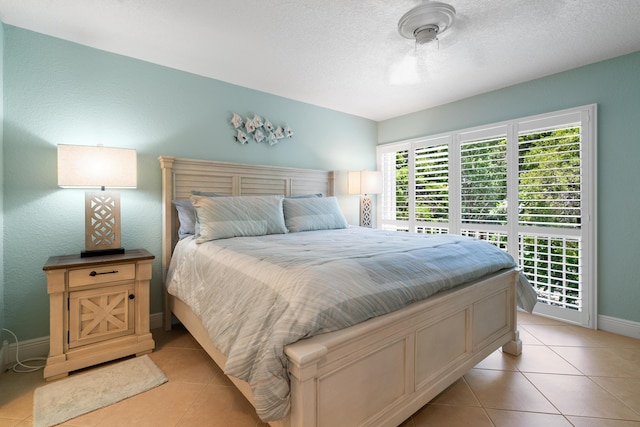 tiled bedroom with access to exterior and a textured ceiling