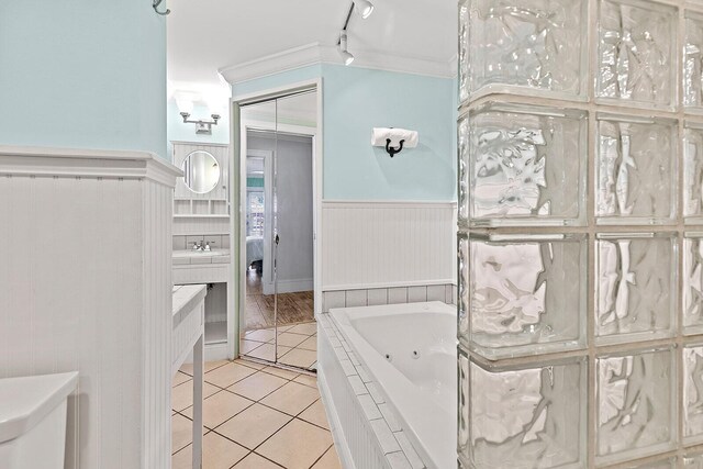 bathroom with sink, crown molding, track lighting, a relaxing tiled tub, and tile patterned flooring