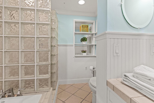 bathroom with tile patterned flooring, ornamental molding, and toilet