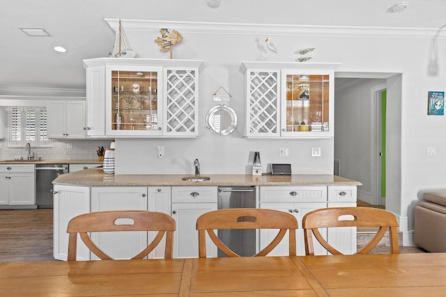 kitchen with dishwasher, sink, white cabinets, and crown molding