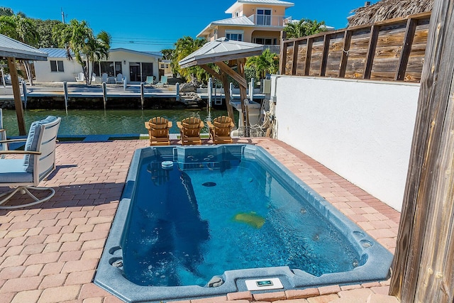 view of pool featuring a water view and a patio area