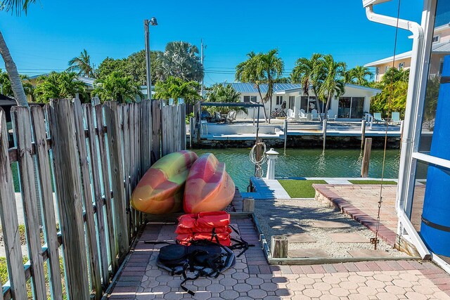 view of patio with a water view and a dock