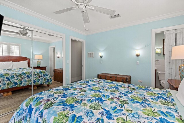 bedroom featuring ensuite bathroom, wood-type flooring, ceiling fan, crown molding, and a closet