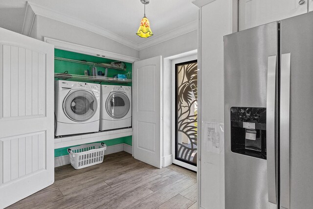 washroom featuring separate washer and dryer, ornamental molding, and light wood-type flooring