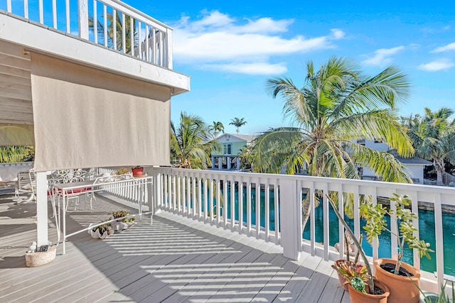 deck with a swimming pool and a water view