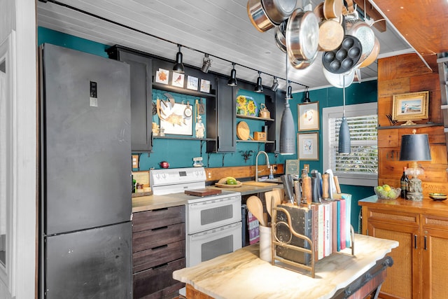 kitchen with range with two ovens, sink, and refrigerator