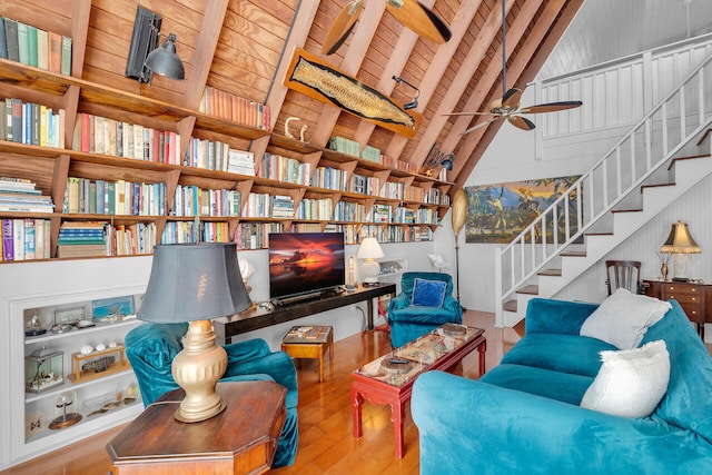 living area featuring ceiling fan, vaulted ceiling with beams, wood ceiling, and light hardwood / wood-style flooring