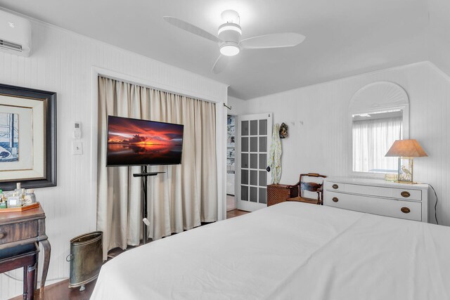 bedroom with a wall mounted air conditioner and ceiling fan