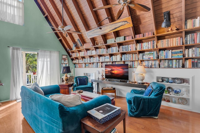 living area with ceiling fan, high vaulted ceiling, light hardwood / wood-style floors, wooden ceiling, and beamed ceiling