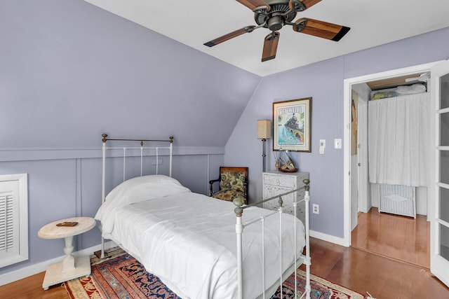 bedroom with dark wood-type flooring, ceiling fan, lofted ceiling, and radiator