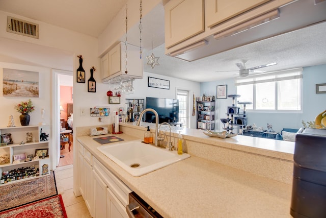 kitchen featuring decorative light fixtures, sink, light tile patterned floors, ceiling fan, and a textured ceiling