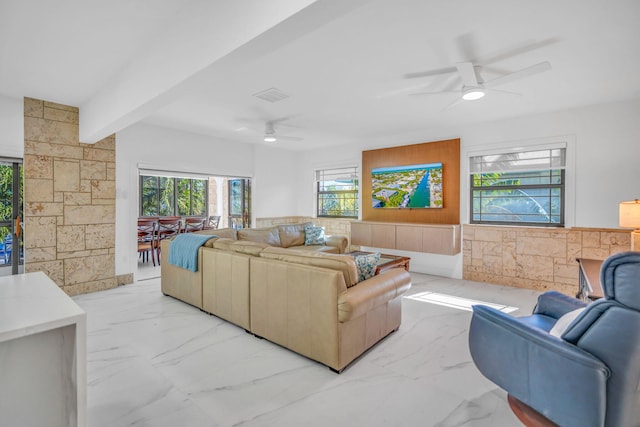 living room featuring beamed ceiling and ceiling fan