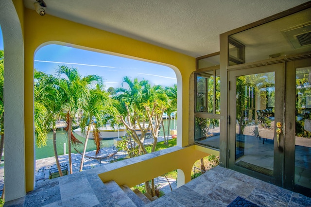 sunroom / solarium featuring a water view